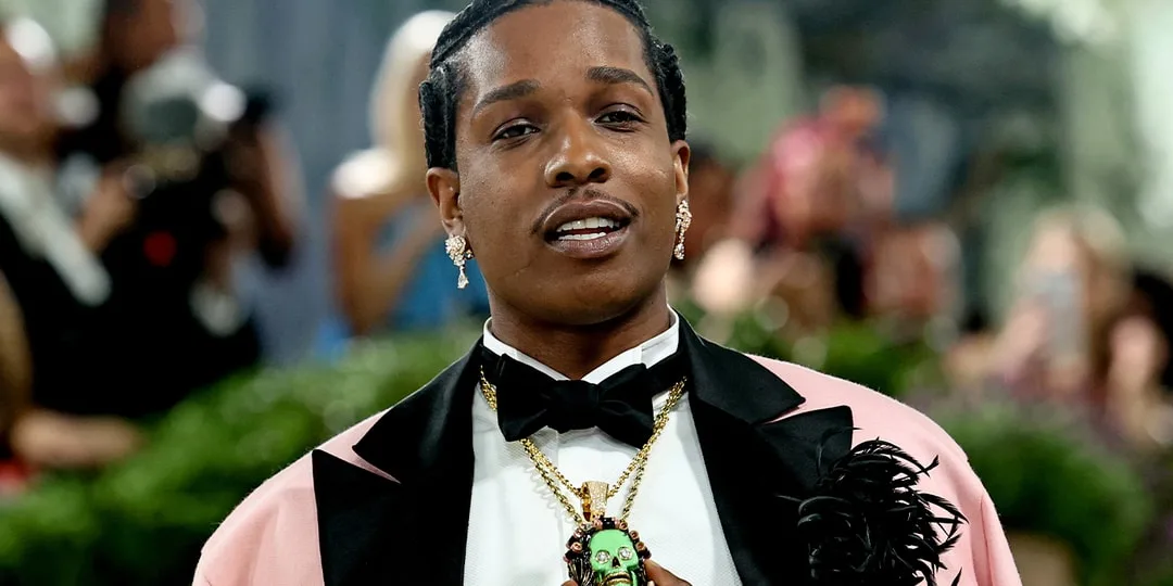 Homme élégant en costume avec pendentif vert, événement de mode.