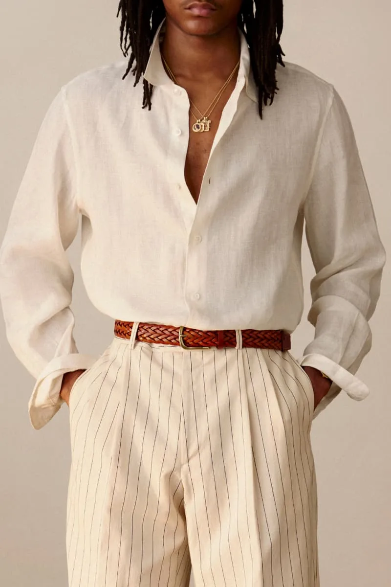 Personne portant une chemise blanche et un pantalon à rayures.