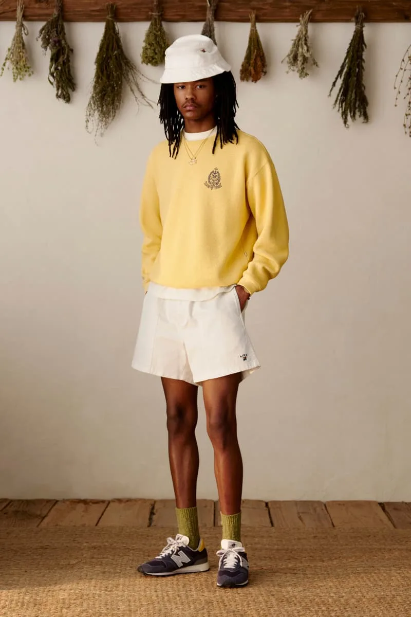 Personne en tenue décontractée avec chapeau et pull jaune