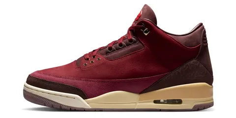 Chaussure de sport rouge et marron avec semelle beige et détails dorés.