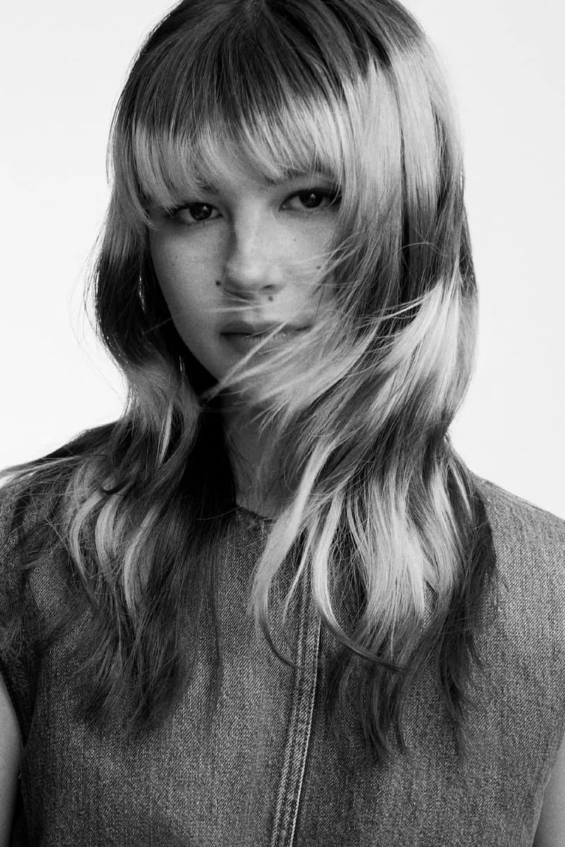 Femme avec coupe dégradée et frange, pose en noir et blanc