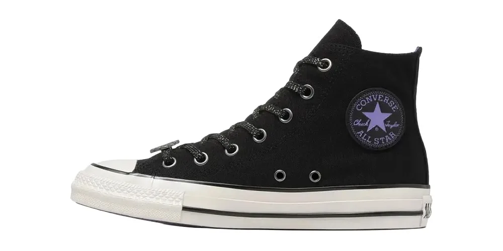 Chaussure montante Converse noire avec semelle blanche et logo All Star.