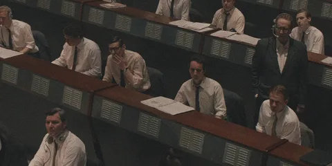 Salle de contrôle avec des hommes en chemises blanches et cravates.