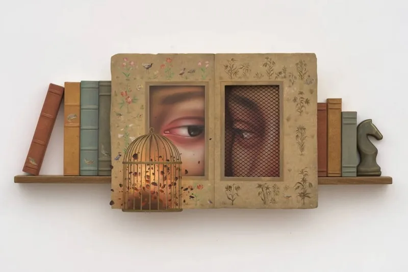 Installations artistiques avec livres, cage et portraits d'yeux