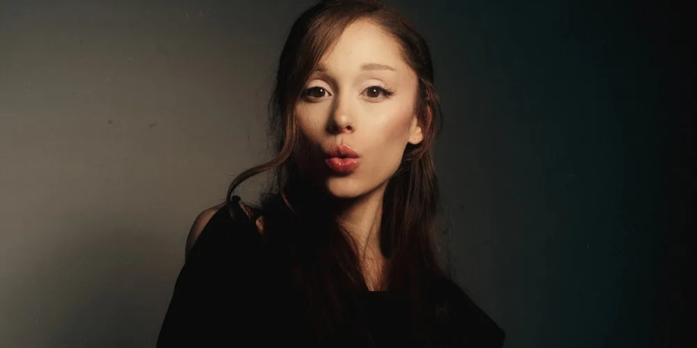 Femme posant avec un fond sombre, expression dramatique.