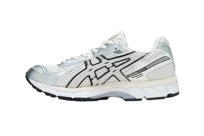 Chaussure de sport blanche et grise avec motif noir sur le côté.