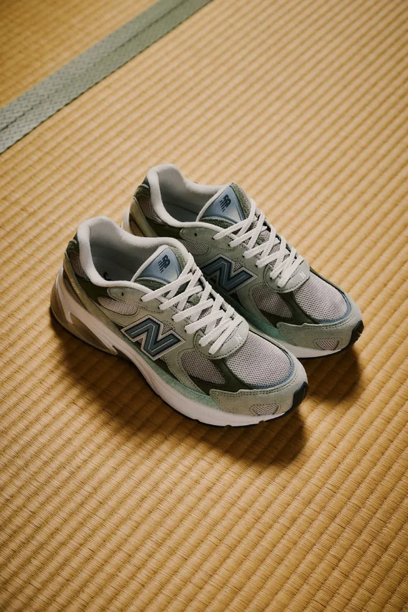 Paire de baskets New Balance vertes et blanches sur un tatami.