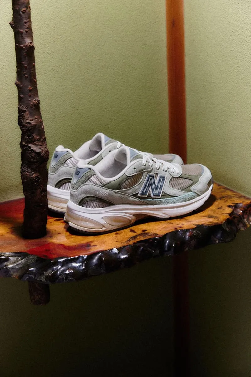 Chaussures sport New Balance sur étagère en bois.