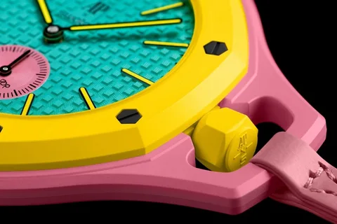 Montre colorée avec boîtier jaune et rose, cadran turquoise.