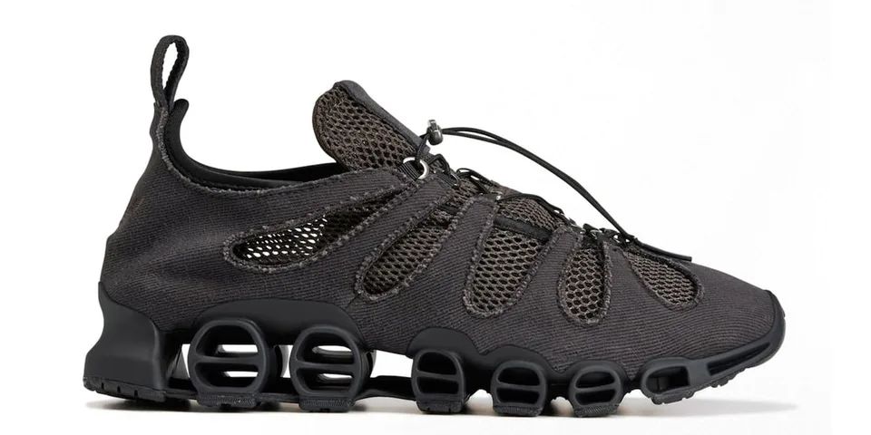 Chaussure noire avec design innovant et semelle distincte.