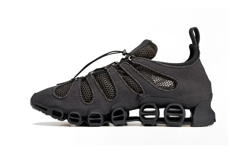 Chaussure noire avec semelle à ressorts visibles.