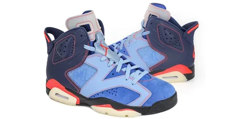 Chaussures de sport bleu clair et bleu foncé avec détails rouges et semelles beiges.