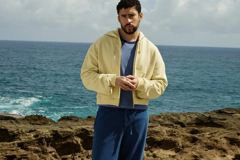 Homme en tenue décontractée devant la mer, sur des rochers.