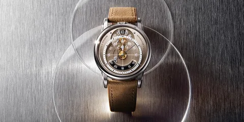 Montre avec bracelet marron sur fond métallique.