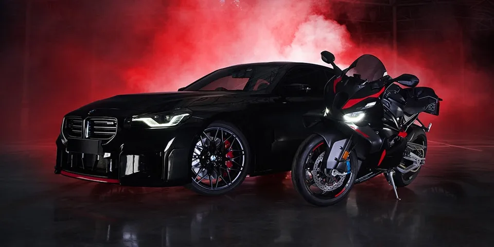 Voiture noire et moto avec fumée rouge en arrière-plan.