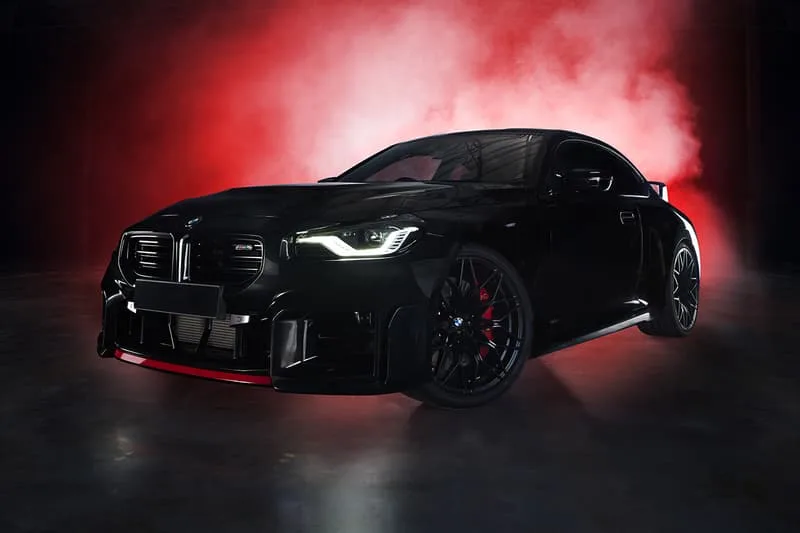 Voiture noire sportive avec fond de fumée rouge sur un sol sombre.