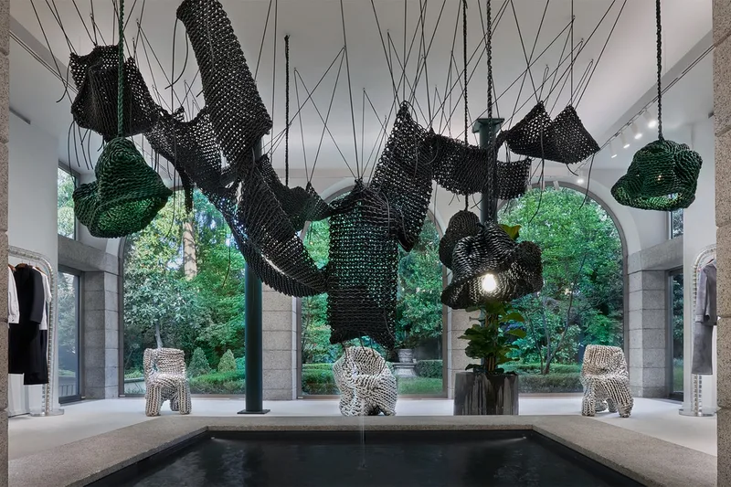 Installation artistique avec des sculptures suspendues dans une galerie lumineuse.