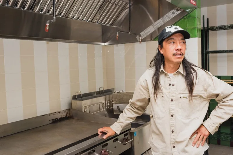 Homme dans une cuisine commerciale avec plaque chauffante.
