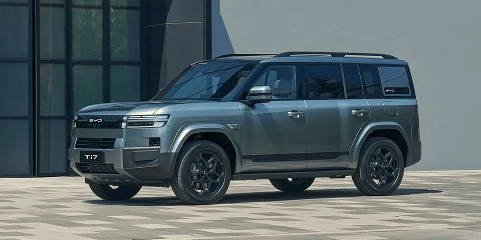 SUV gris moderne garé devant un bâtiment.