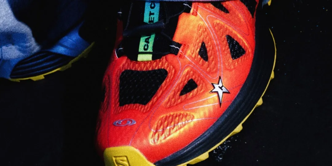 Chaussure de sport rouge vif et noire avec semelle jaune.