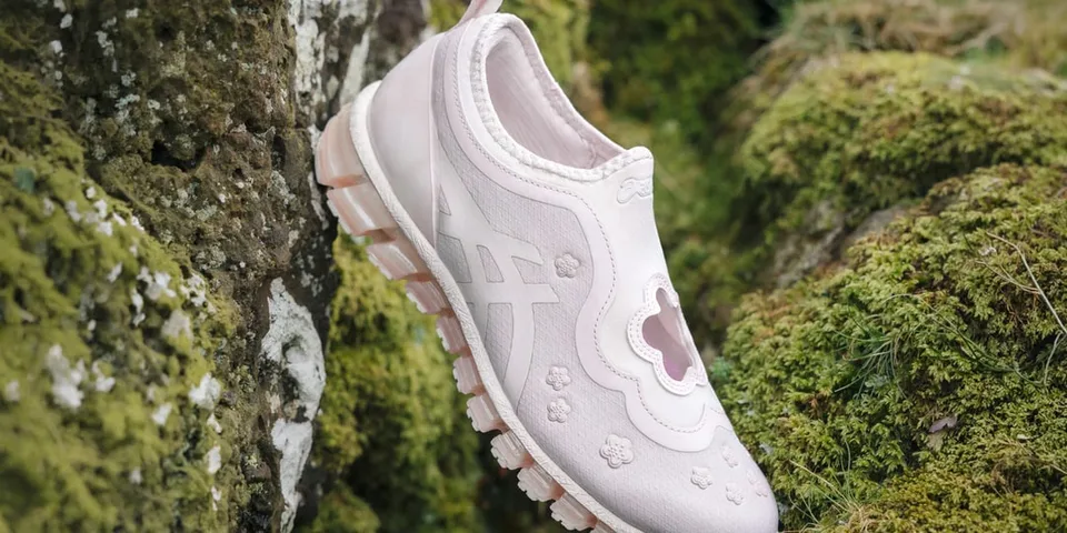 Chaussure rose avec motif floral sur fond de mousse verte.