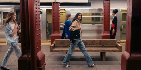 Quatre personnes marchant sur un quai de métro urbain.