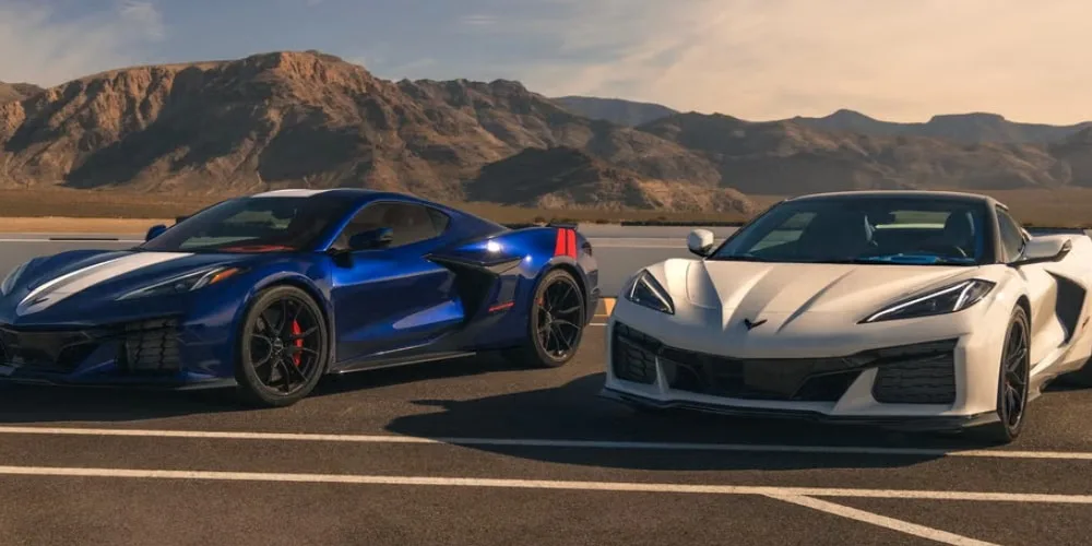Deux voitures de sport devant des montagnes.