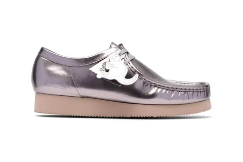 Chaussure beurrée brillante avec logo blanc sur le côté, semelle beige.