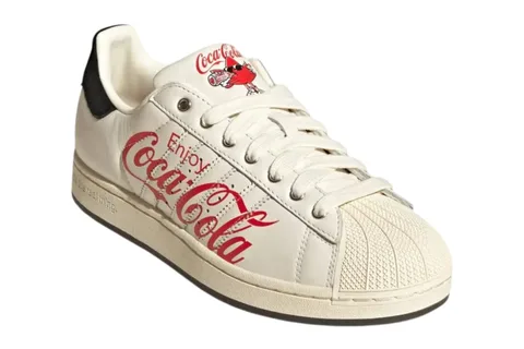 Chaussure blanche avec logo Coca-Cola rouge sur le côté et dessin.