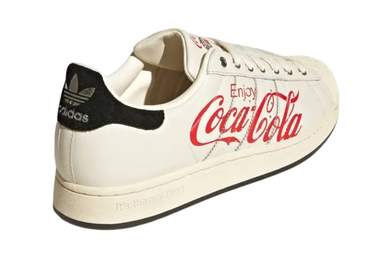Chaussure Adidas blanche avec logo Coca-Cola vintage en rouge.