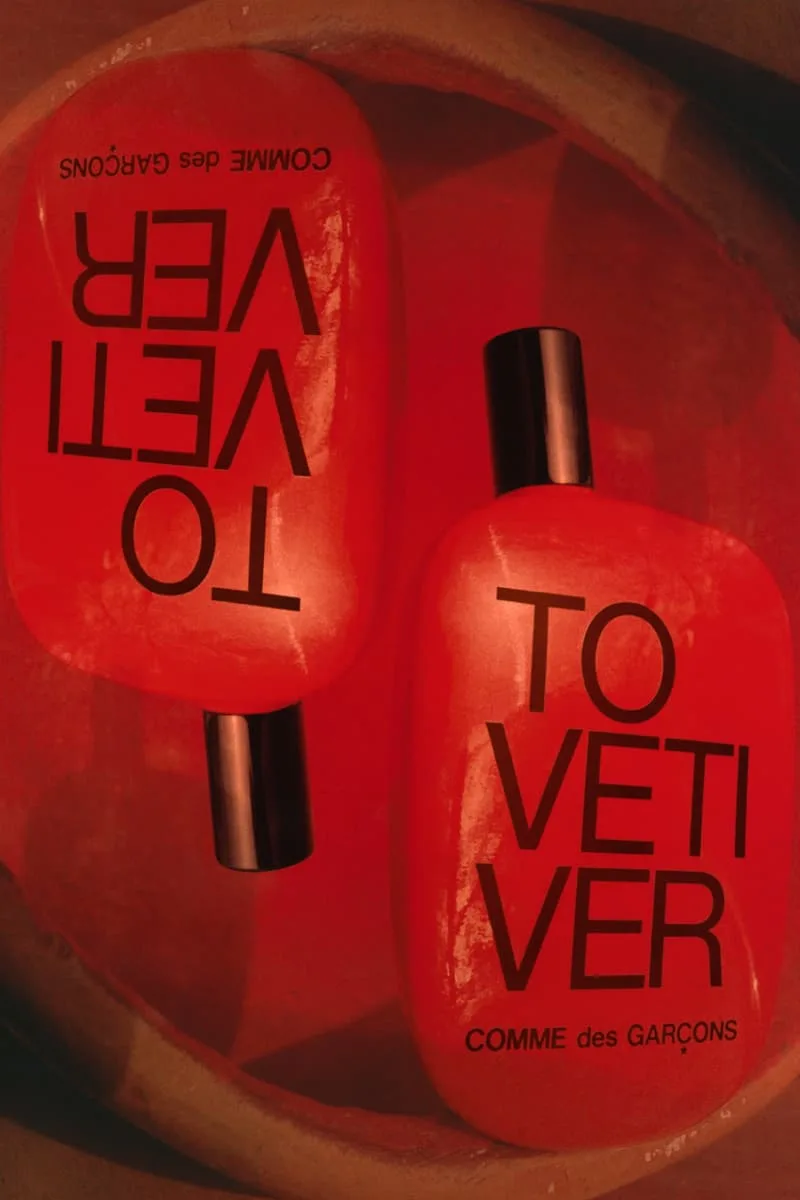Deux flacons de parfum rouges de Comme des Garçons sur fond rouge.