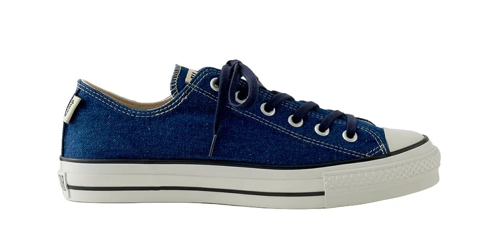 Chaussure en toile bleue à semelle blanche et lacets.