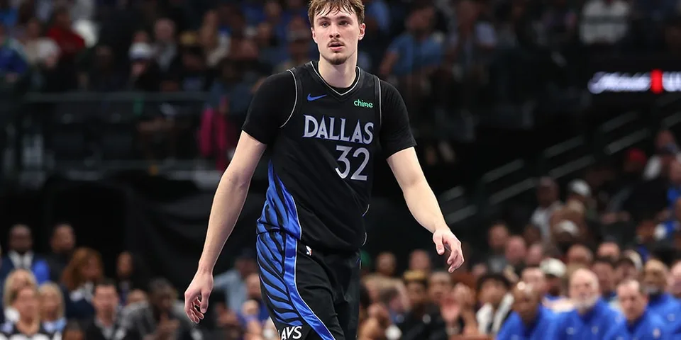 Joueur de basket avec maillot noir Dallas sur le terrain.