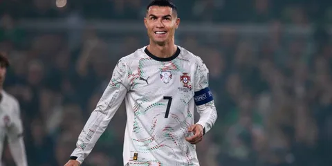 Footballeur souriant en maillot blanc avec brassard de capitaine.