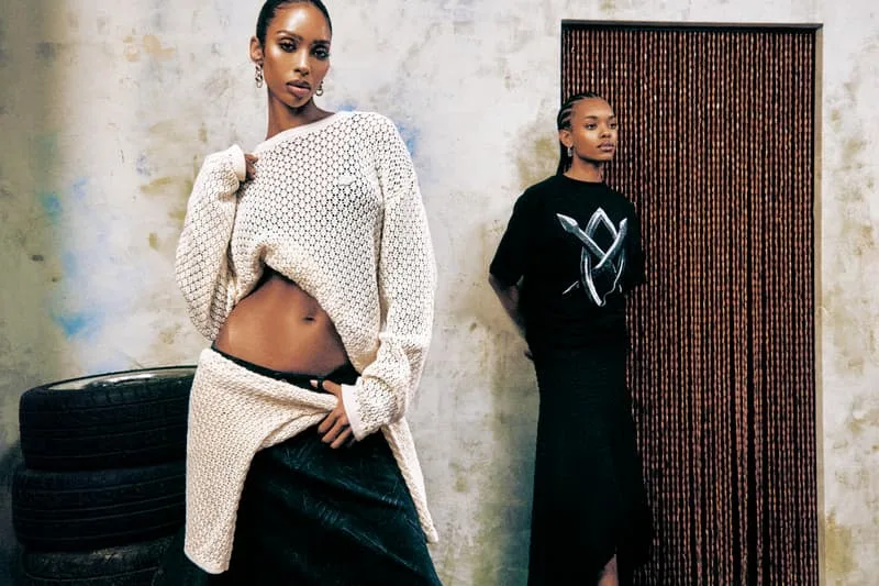 Deux mannequins posant avec des vêtements modernes dans un décor industriel.