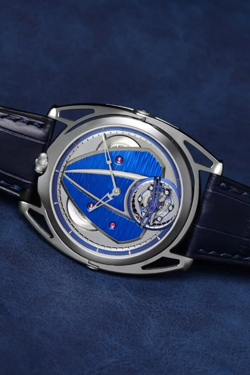 Montre avec cadran bleu et mécanisme visible sur fond bleu.