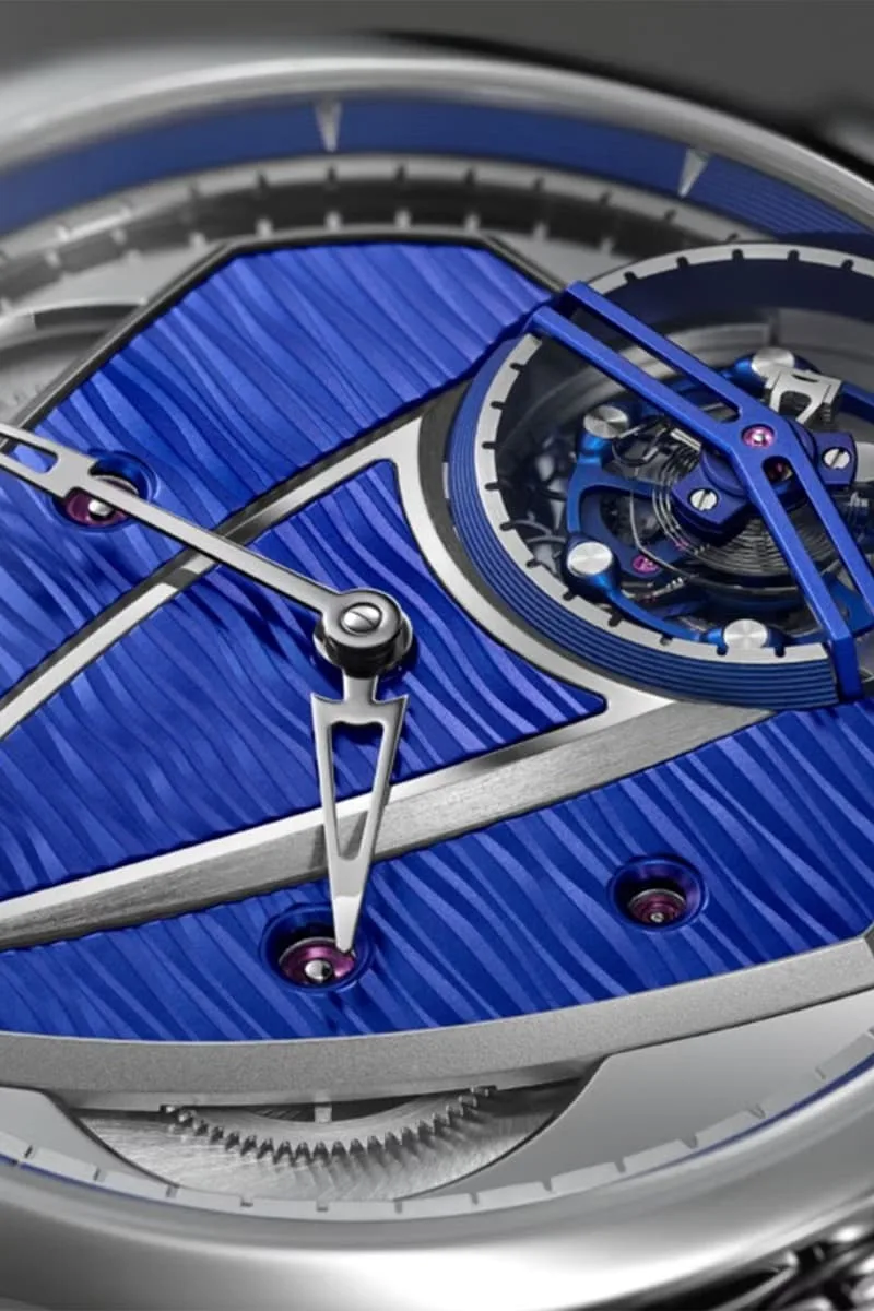 Montre avec cadran bleu texturé et mécanisme visible.