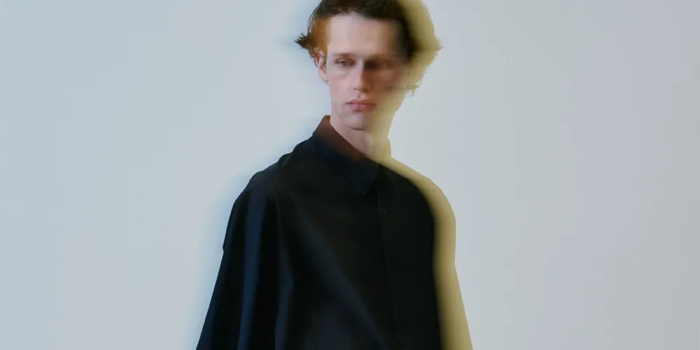 Homme flou en chemise noire, effet de mouvement.