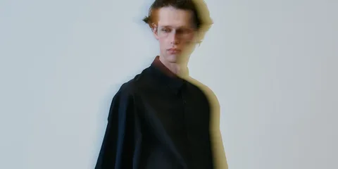 Homme flou en chemise noire, effet de mouvement.