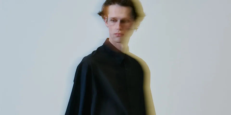 Homme flou en chemise noire, effet de mouvement.