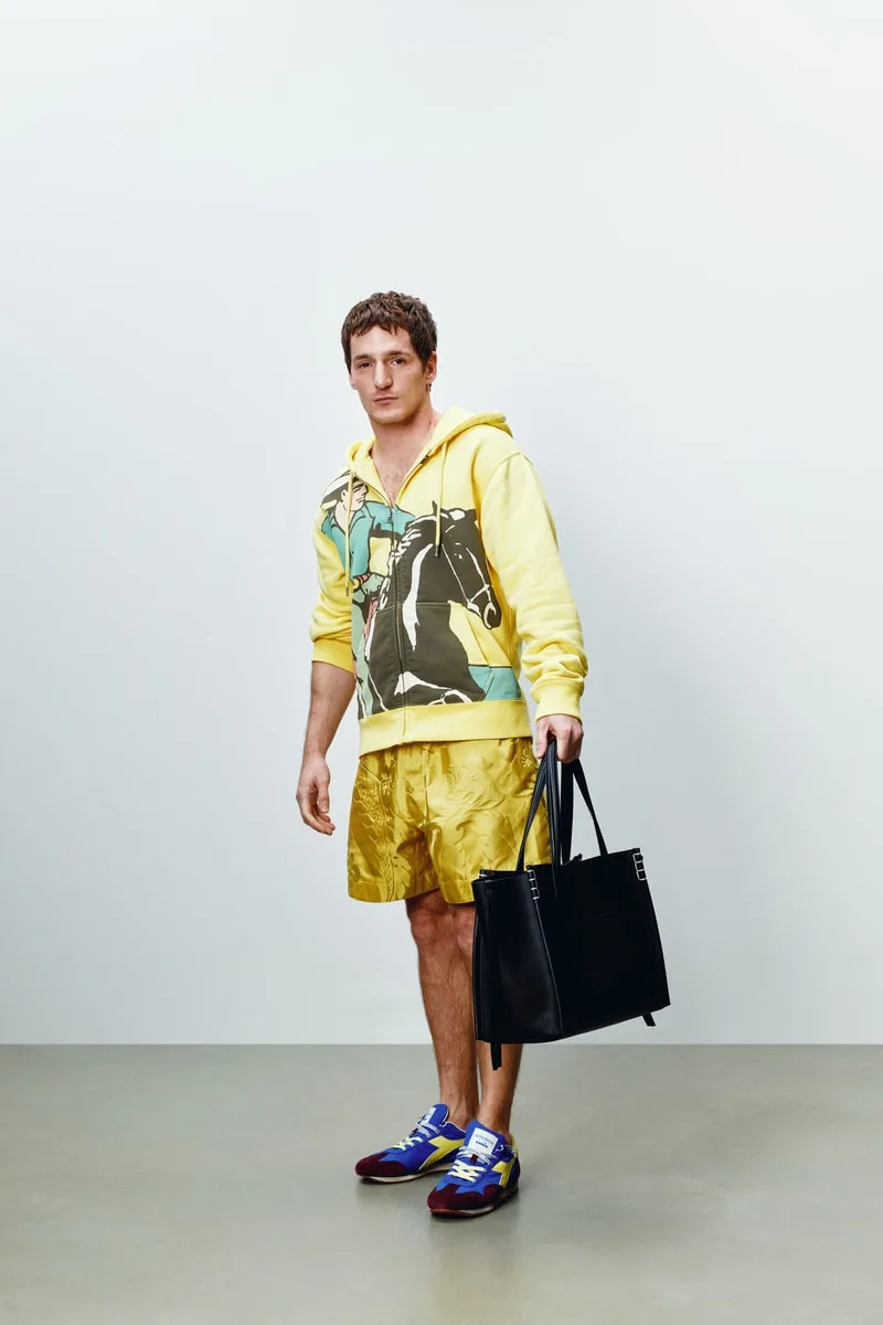 Homme en tenue décontractée avec sac noir, fond neutre