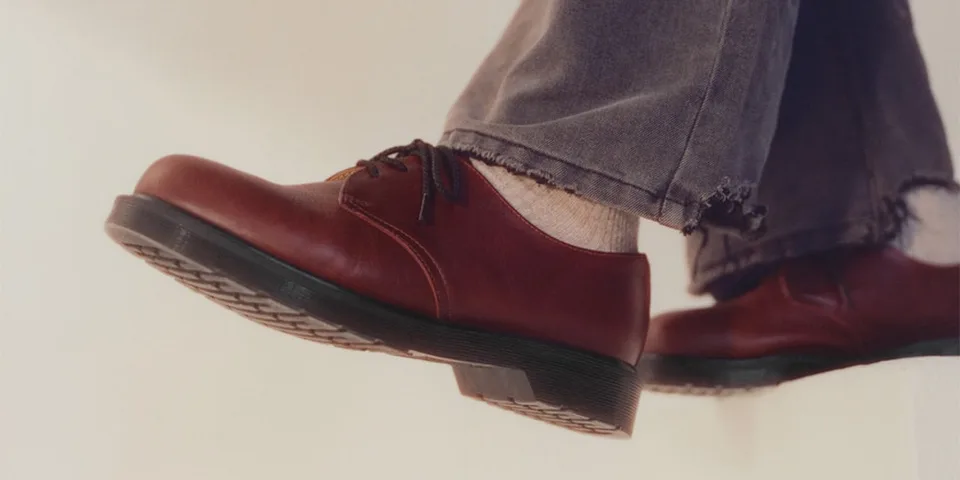Chaussures marron avec un jean usé, vue de côté.