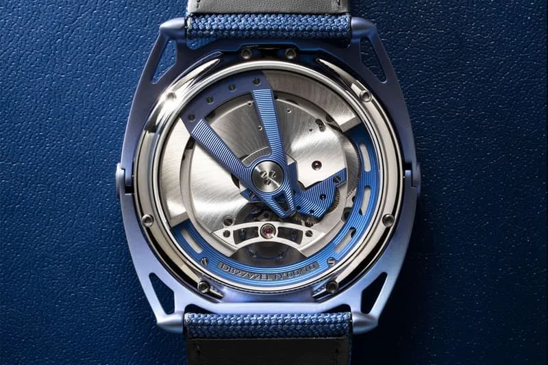 Montre mécanique avec boîtier bleu et bracelet, sur fond bleu.