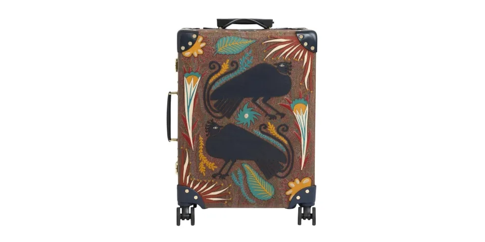 Valise avec motifs décoratifs de plumes et créatures noires.
