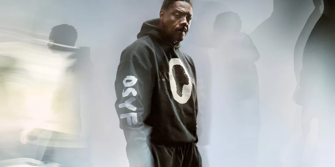 Homme avec sweat noir, fond flou artistique.