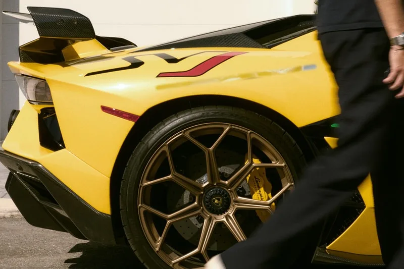 Voiture de sport jaune avec homme en mouvement au premier plan.