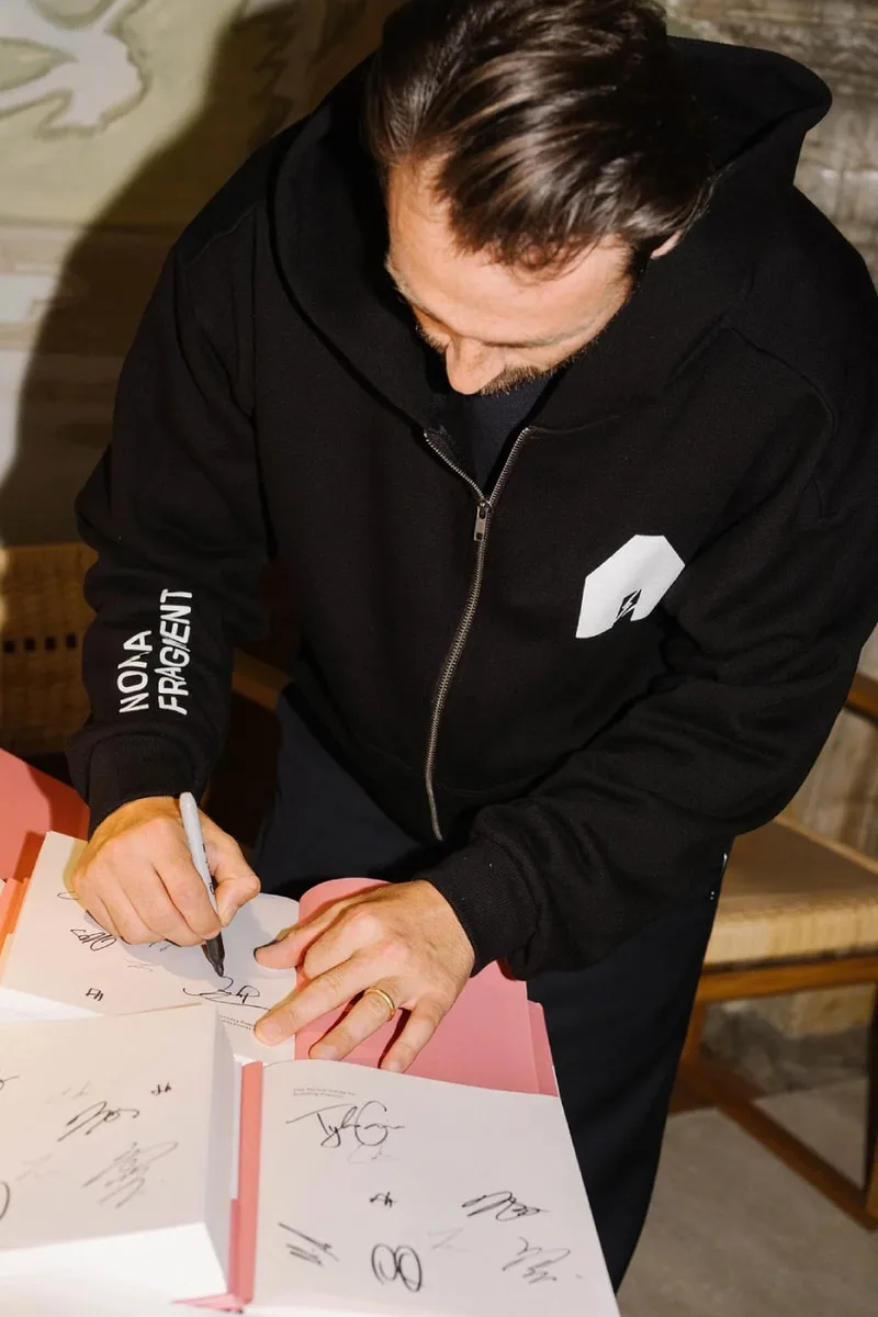 Personne signe des livres en sweat à capuche noir