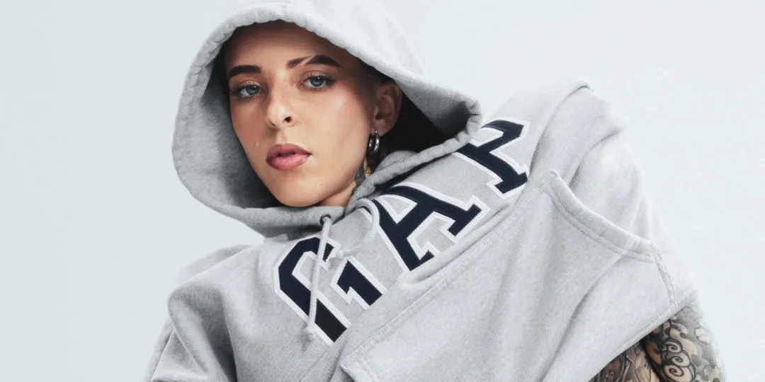 Personne en sweat à capuche gris avec logo GAP, vue de près.