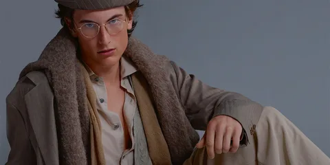 Homme en tenue élégante avec chapeau et lunettes.
