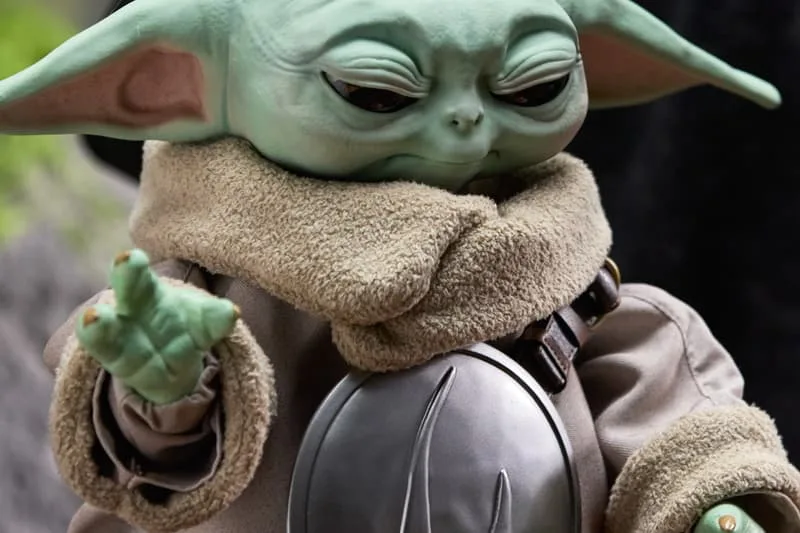 Une créature verte ressemblant à un bébé alien avec des oreilles pointues.